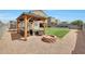 A landscaped backyard features a gazebo with seating and a fire pit for outdoor relaxation at 30683 W Amelia Ave, Buckeye, AZ 85396