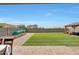 Backyard featuring a gazebo with outdoor seating, artificial turf and garden area with blue skies at 30683 W Amelia Ave, Buckeye, AZ 85396