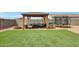 A well-manicured backyard offers a cozy gazebo with comfortable seating, perfect for entertaining at 30683 W Amelia Ave, Buckeye, AZ 85396