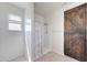 Tiled bathroom with a walk-in shower and a wood-style sliding barn door at 30683 W Amelia Ave, Buckeye, AZ 85396