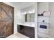 Bathroom with double vanity, large mirror, shelving, and a wood-style sliding barn door at 30683 W Amelia Ave, Buckeye, AZ 85396