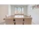 Elegant dining room showcasing a wooden table and six upholstered chairs, bathed in natural light from the window at 30683 W Amelia Ave, Buckeye, AZ 85396