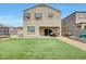 Exterior of house featuring a backyard with grill, patio seating, and grassy area at 30683 W Amelia Ave, Buckeye, AZ 85396