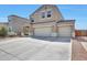 Two story home featuring a two-car garage and manicured landscaping, under a bright blue sky at 30683 W Amelia Ave, Buckeye, AZ 85396