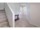 Hallway with staircase, accent table and tile flooring that lead into a bright home at 30683 W Amelia Ave, Buckeye, AZ 85396