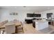 Well-lit kitchen and dining area with stainless steel appliances, granite countertops, dark cabinetry, and a center island at 30683 W Amelia Ave, Buckeye, AZ 85396