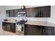 Kitchen featuring dark cabinets and stainless steel appliances at 30683 W Amelia Ave, Buckeye, AZ 85396