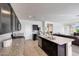 Open kitchen with dark wood cabinets, granite countertops, and a view to the living area at 30683 W Amelia Ave, Buckeye, AZ 85396