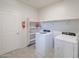 Laundry room with washer, dryer, shelving, and a fire extinguisher at 30683 W Amelia Ave, Buckeye, AZ 85396