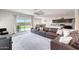 Open-concept living area with a leather sofa, flowing to the kitchen, and a glass door leading to an outdoor patio at 30683 W Amelia Ave, Buckeye, AZ 85396