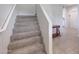 A carpeted staircase with white walls leads to the upper level of the home at 30683 W Amelia Ave, Buckeye, AZ 85396