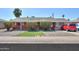 Charming red brick home featuring manicured front yard, tidy landscaping, and a cozy covered porch at 3413 W Ocotillo Rd, Phoenix, AZ 85017