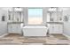 Beautiful bathroom with double vanity sinks, a soaking tub, and a large window at 3842 E Fountain St, Mesa, AZ 85205