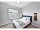 Comfortable bedroom with a stylish blue headboard, plush pillows, and a window at 3842 E Fountain St, Mesa, AZ 85205