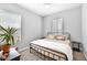 Inviting bedroom features a metal frame bed, sun-filled windows, and neutral decor at 3842 E Fountain St, Mesa, AZ 85205