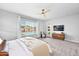 Spacious bedroom with a ceiling fan, plush carpeting, and a window view of the backyard pool at 3842 E Fountain St, Mesa, AZ 85205