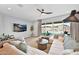 Bright living room with comfortable seating, a modern ceiling fan, and a view of the backyard pool area at 3842 E Fountain St, Mesa, AZ 85205