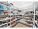 Spacious walk-in pantry with bright lighting and organized white shelving for ample storage solutions at 3842 E Fountain St, Mesa, AZ 85205