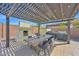 Inviting outdoor dining area under a pergola, complete with fireplace and barbecue setup at 3842 E Fountain St, Mesa, AZ 85205