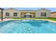 Back of house with pool and fountains, grassy area, and umbrella covered outdoor seating at 3842 E Fountain St, Mesa, AZ 85205
