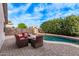 Backyard pool with red patio furniture and green foliage at 3907 E Topeka Dr, Phoenix, AZ 85050