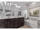 Bathroom boasts dual sinks, stylish lighting, and a luxurious soaking tub with marble accents at 3907 E Topeka Dr, Phoenix, AZ 85050
