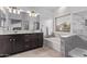A bathroom with double sinks, a soaking tub, a shower, and marble countertops at 3907 E Topeka Dr, Phoenix, AZ 85050