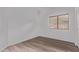 Neutral bedroom space with wood-look floors, a window, and white walls ready for personalization at 3907 E Topeka Dr, Phoenix, AZ 85050