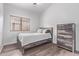 A bedroom with wood floors, a queen bed, a wood dresser, and a window with blinds at 3907 E Topeka Dr, Phoenix, AZ 85050