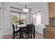 Bright breakfast nook features a modern light fixture and a view of the neighborhood through large windows at 3907 E Topeka Dr, Phoenix, AZ 85050