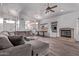 A living room with a gray sofa, a ceiling fan, wood floors, and a fireplace at 3907 E Topeka Dr, Phoenix, AZ 85050