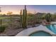 A private backyard view of desert landscaping, pool, and distant golf course at 41424 N Club Pointe Dr, Anthem, AZ 85086