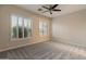 Light-filled bedroom with shuttered windows, plush carpeting, and a ceiling fan at 41424 N Club Pointe Dr, Anthem, AZ 85086