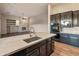 Kitchen island with sink and marble countertops and view into the Gathering room at 41424 N Club Pointe Dr, Anthem, AZ 85086