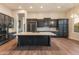 Gourmet kitchen with island, modern appliances, dark cabinets, and hardwood flooring at 41424 N Club Pointe Dr, Anthem, AZ 85086