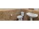 Charming powder room with stylish tile walls, pedestal sink, and modern fixtures at 41424 N Club Pointe Dr, Anthem, AZ 85086