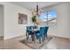 Inviting dining room with blue velvet chairs, chandelier lighting, and a view from the bright window at 4148 W Dayflower Dr, San Tan Valley, AZ 85144