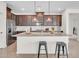 Open kitchen featuring dark cabinets, a subway tile backsplash and an island with seating at 4148 W Dayflower Dr, San Tan Valley, AZ 85144