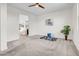 Spacious living room with plush carpet, ceiling fan, and an open entryway to the kitchen at 4148 W Dayflower Dr, San Tan Valley, AZ 85144