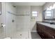 Bathroom featuring a sleek shower, granite countertops, dark wood cabinets, a large mirror, and a window for natural light at 4527 N 12Th Ave, Phoenix, AZ 85013
