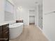 Bright bathroom featuring a soaking tub, glass-enclosed shower, and dark wood vanity at 4795 W Hunter Trl, San Tan Valley, AZ 85144