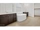 Beautiful bathroom showcases double vanities, soaking tub, and neutral tile flooring at 4795 W Hunter Trl, San Tan Valley, AZ 85144