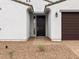 Close up of the home's front door, surrounded by neutral stucco and brick landscaping at 4795 W Hunter Trl, San Tan Valley, AZ 85144