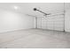 A clean, empty garage with a concrete floor and closed garage door at 4795 W Hunter Trl, San Tan Valley, AZ 85144