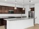 Stylish kitchen boasts granite countertops, dark wood cabinetry, and stainless steel appliances at 4795 W Hunter Trl, San Tan Valley, AZ 85144