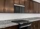 Modern kitchen features stainless steel appliances, granite countertops and dark wood cabinets at 4795 W Hunter Trl, San Tan Valley, AZ 85144