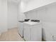 Well-lit laundry room with tile flooring featuring white washer and dryer at 4795 W Hunter Trl, San Tan Valley, AZ 85144