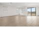 Bright living room with tile floor, white walls and sliding glass doors to the backyard at 4795 W Hunter Trl, San Tan Valley, AZ 85144