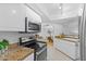 Well-lit kitchen with white cabinets, granite countertops, and stainless steel appliances, open to the dining area at 5104 N 32Nd St # 311, Phoenix, AZ 85018