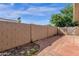 Enclosed backyard space with a brick paver patio, block wall, and mature trees, offering privacy at 5316 S Palm Dr, Tempe, AZ 85283
